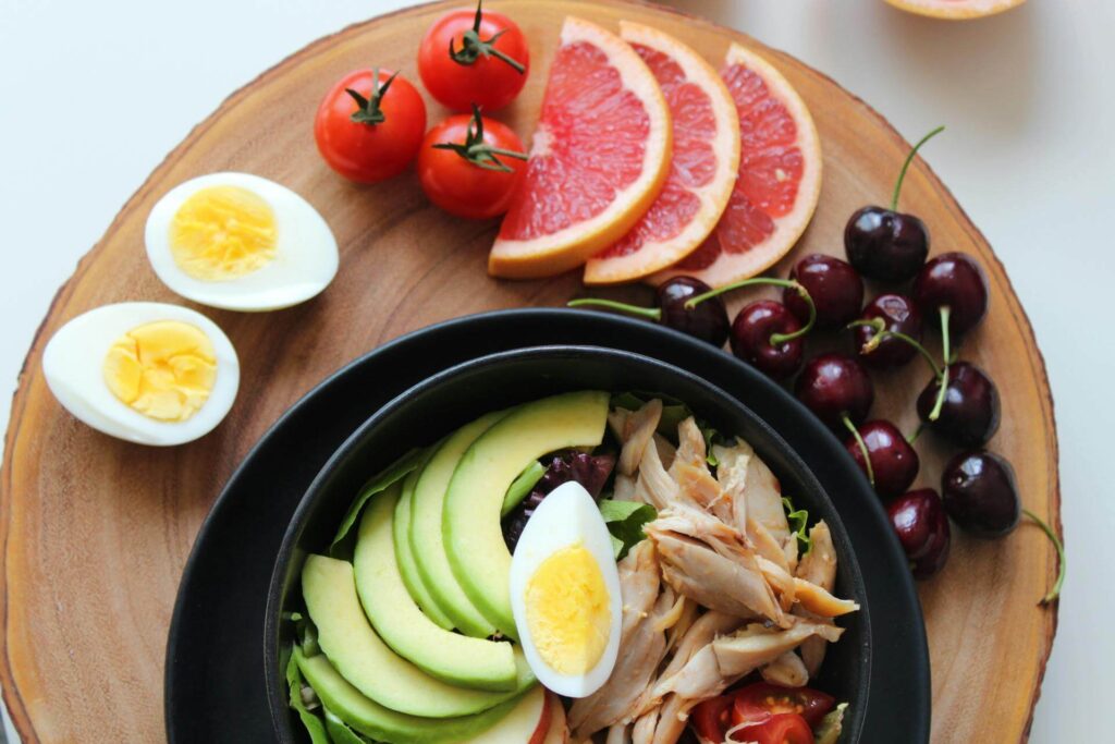 high fertility foods for getting pregnant, eggs, avocados, citrus fruits, chicken, in bowl